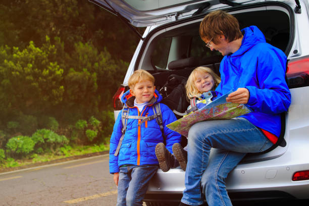istock father with kids looking at map while travel by car 638775026