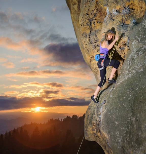 istock Female climber climbing with rope on a rocky wall 638775108
