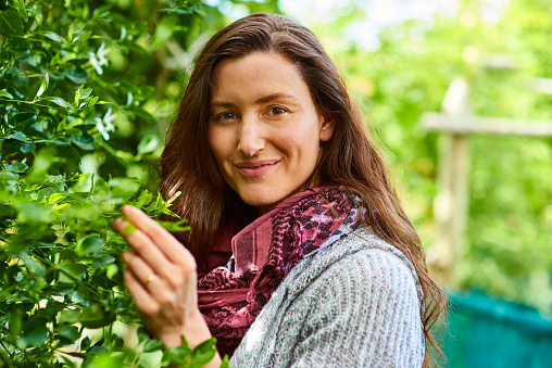 Portrait of a smiling woman standing in her organic garden