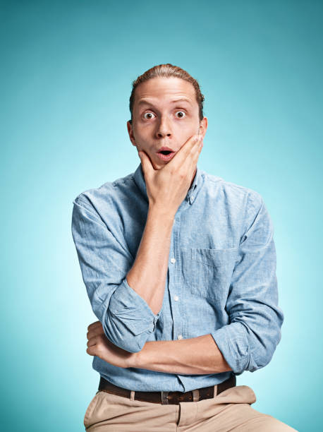 istock The surprised young man over blue background 638777210
