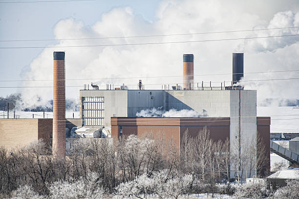 Horizontal image of  power station in winter in Saskatoon, Saskatchewan.  The plant used to be fueled with coal but is powered by natural gas now.  Steam and smoke can be seen coming from the station on a cold winter's day.