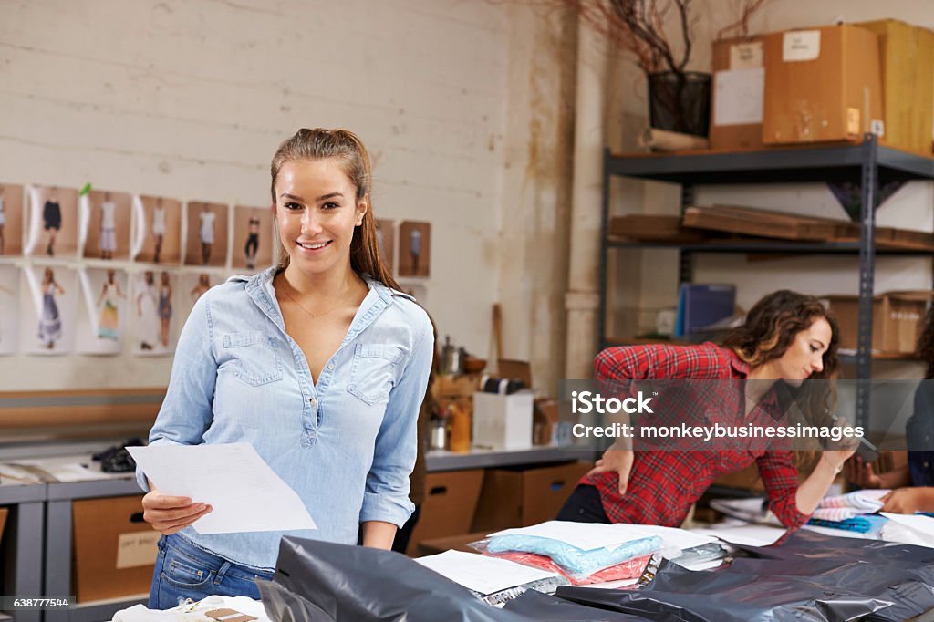 Young woman packing orders for distribution smiles to camera Freight Transportation Stock Photo