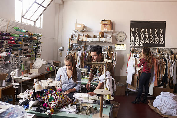 istock Machinist and colleagues working at a clothing design studio 638777644