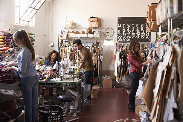 istock Team of people working together in clothes design studio 638777886