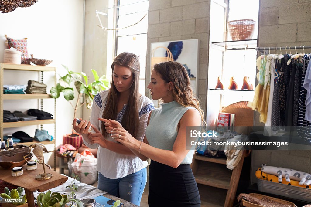 Female shop assistant talking to customer in a clothes shop Retail Stock Photo