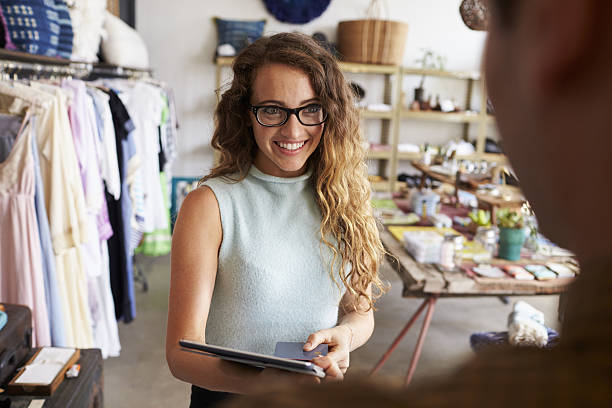 female boutique manager greeting client in shop - adult variation boutique occupation imagens e fotografias de stock