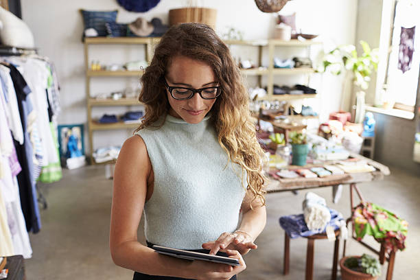 istock Female business owner using tablet computer in clothes shop 638778430