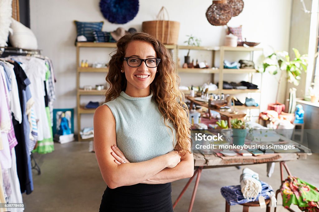 Joven mujer dueña de un negocio en una tienda de ropa, retrato - Foto de stock de Propietario libre de derechos