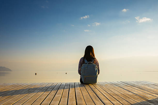 istock Young woman relaxes on lake pier 638780248