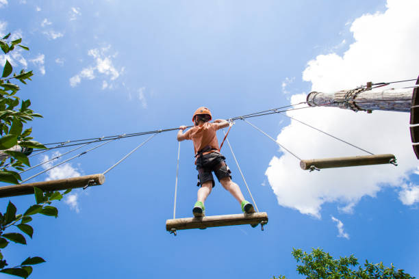 Adventure park fun - boy on ropes course Adventure park fun boy on ropes course canopy tour photos stock pictures, royalty-free photos & images