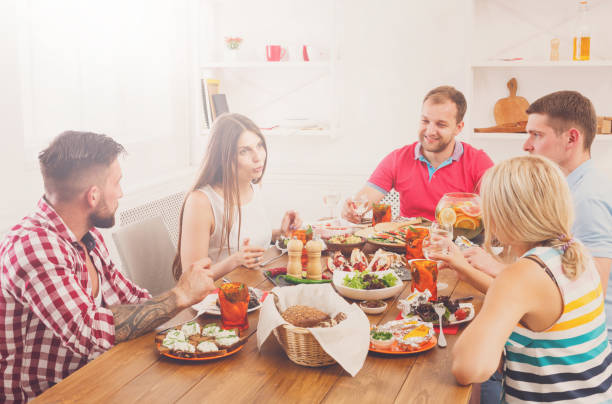 istock Group of happy people at festive table dinner party 638780728