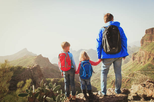 istock father and two kids hiking climbing in mountains 638784486