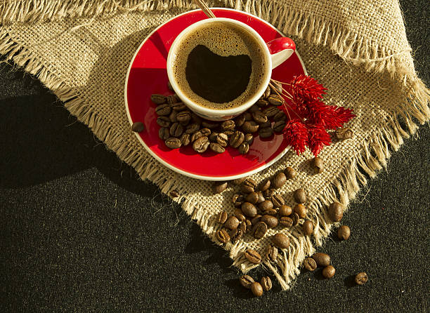 istock Red cup of coffee with coffee beans and  flower 638784508