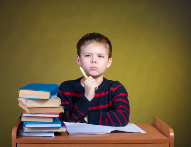 istock Focused kid studying. Tired little boy writing. 638785430