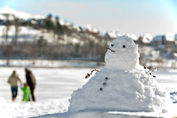 istock snowman and a young couple with a child 638786072