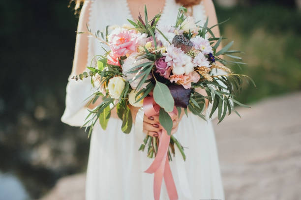 istock The bride with a bouquet on beautiful large lake background 638788848