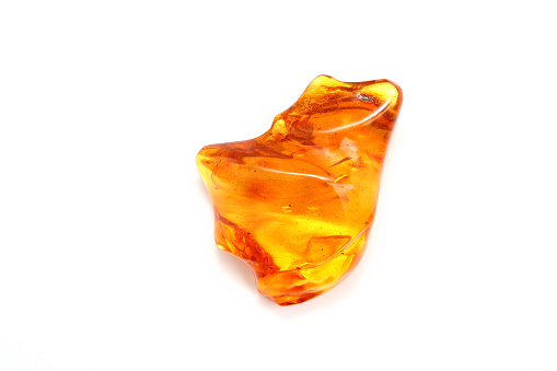 Amber. Transparent amber yellow with a wavy surface. Amber unique shape on white background. View from above