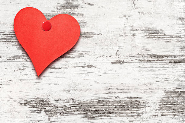 istock Heart shaped note on white weathered wooden wall 638790172