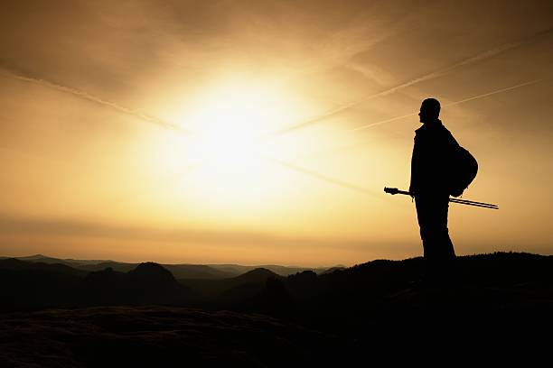 istock Sunny fall. Hiker is standing on peak of rocky mountain 638790398