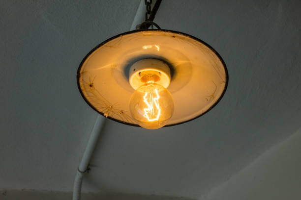 istock Lighting light bulb on the cable in dark room 638791044