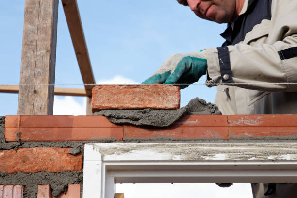 istock bricklayer puts a brick on wall outdoors 638792688