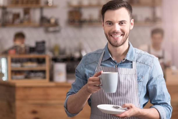 istock Positive smiling man holding cup of coffee. 638795154