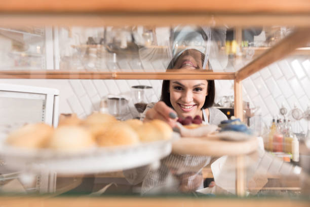 istock Cheerful pretty smiling woman getting cake from display stand. 638799270