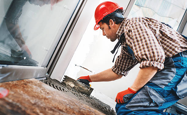 Handyman laying ceramic tiles.