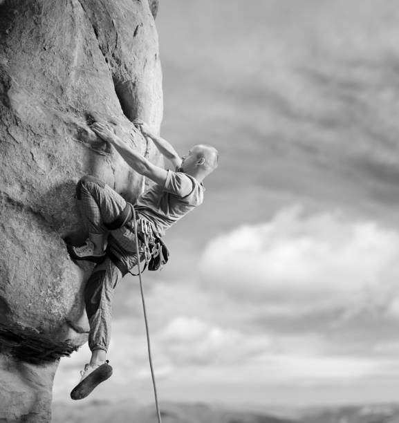 istock Male climber climbing big boulder in nature with rope 638800264