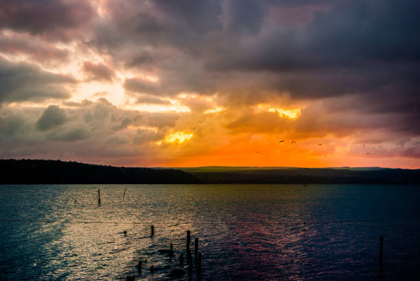 Beautiful blazing sunset landscape at Varna lake near the black sea and orange sky above it with awesome sun golden reflection on calm waves as a background. Amazing sunset.