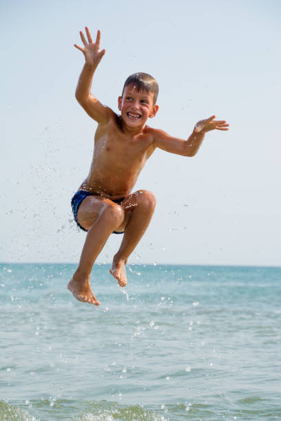 istock Healthy boy jumping in water 638806446