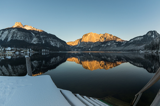 A snow covered stairway into Lake Altaussee just before sunset. On the left the summit of Mount Loser (1837 mt., 6027 ft.) and on the right the so called Trisselwand (1754 mts, 5754 ft.) are illuminated .