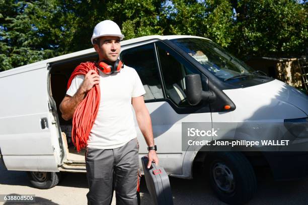 Young Electrician Worker Taking Tools Out Of Professional Truck Van Stock Photo - Download Image Now