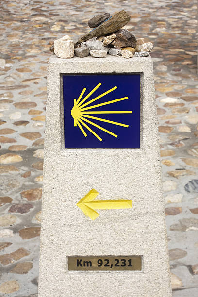 conchiglia pellegrini,simbolo freccia gialla nel camino de santiago - portomarin foto e immagini stock