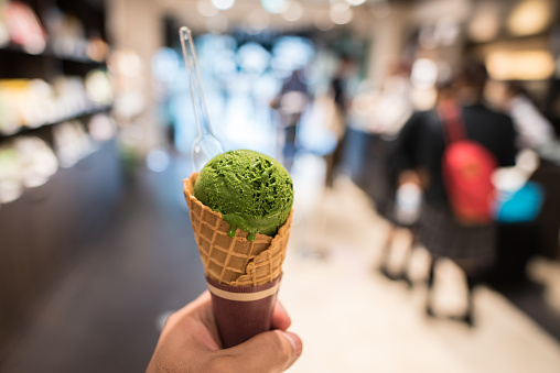 holding green tea ice cream in hand , famous matcha ice cream in tokyo