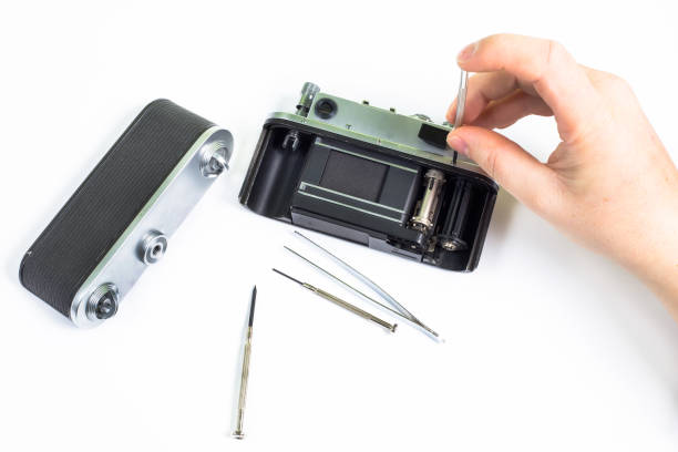 istock Repairing of old  silver camera using screwdriver 638811202