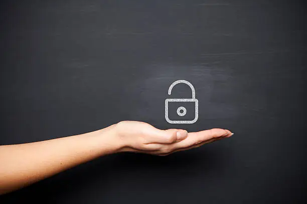 Photo of Human hand with padlock on chalkboard