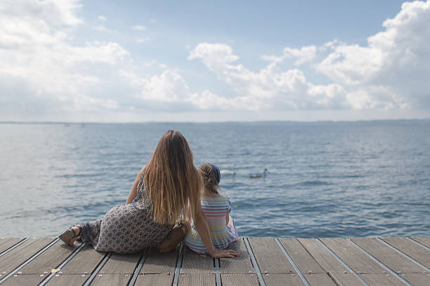 istock Mother and daughter sitting on a landing stage 638818814