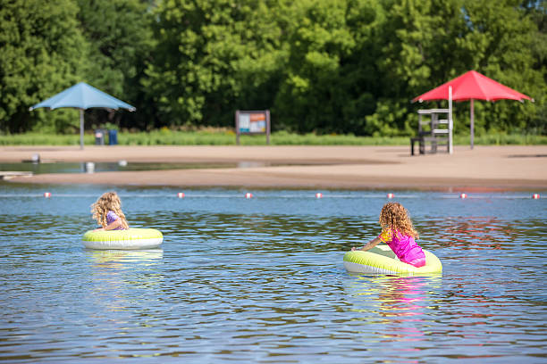 istock Two Girls Floating on Inner Tubes At Swimming Beach 638823816