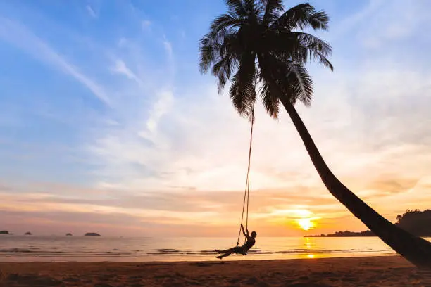 Photo of summer holidays, happy woman on beach swing