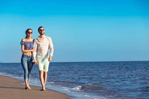 istock Young happy interracial couple walking on beach. 638832554