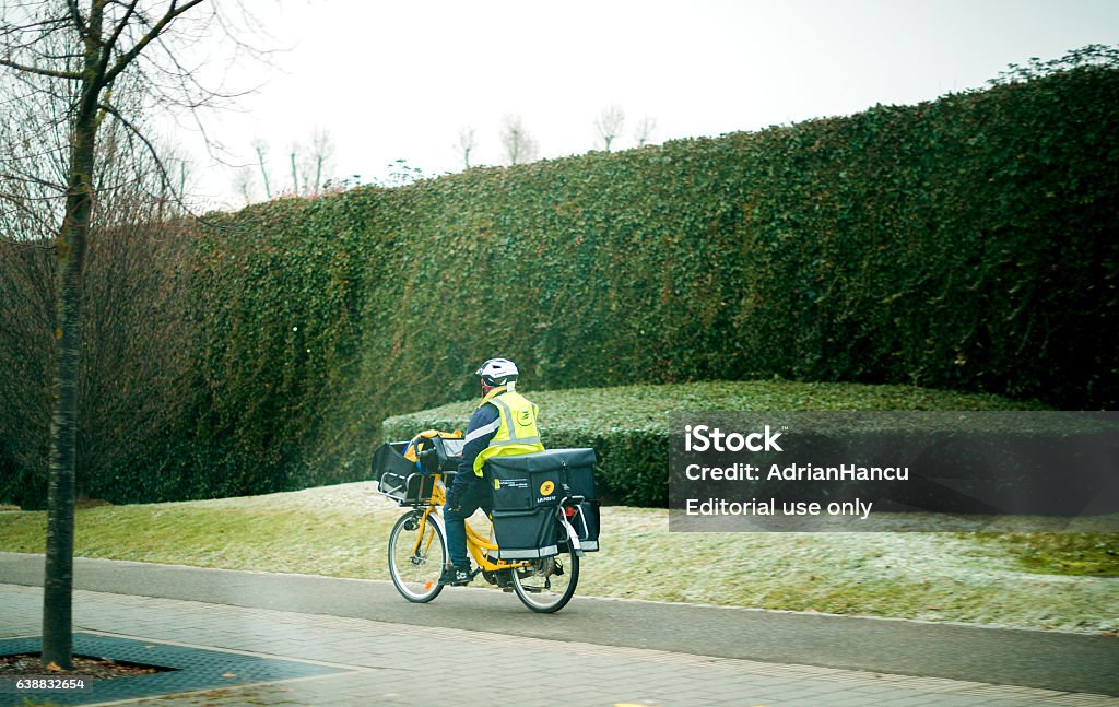 Postman worker on bicycle on cold day - 免版��稅郵政工作人員圖庫照片