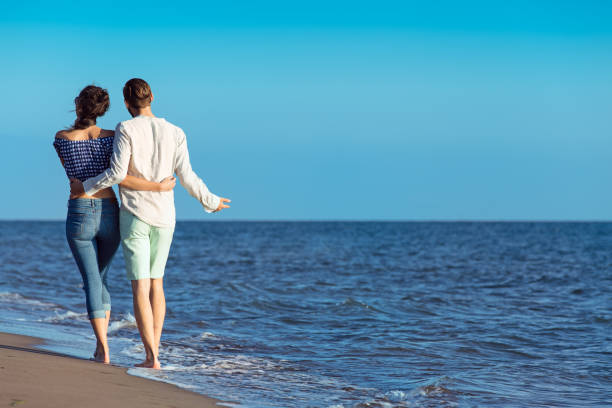 istock Young happy interracial couple walking on beach. 638833114