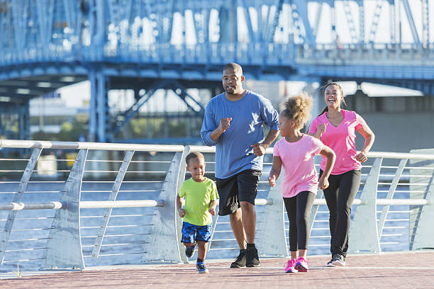 Black family staying fit, power walking on waterfront
