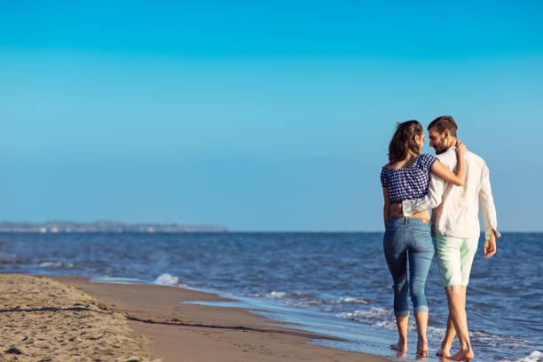 istock Young happy interracial couple walking on beach. 638834288