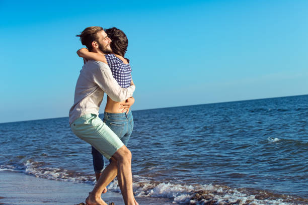 istock happy couple running on the beach 638834636