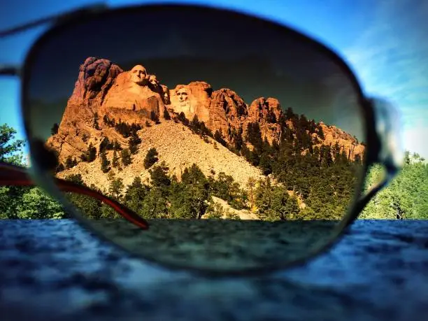 Mount Rushmore seen thru a pair of tinted sunglasses