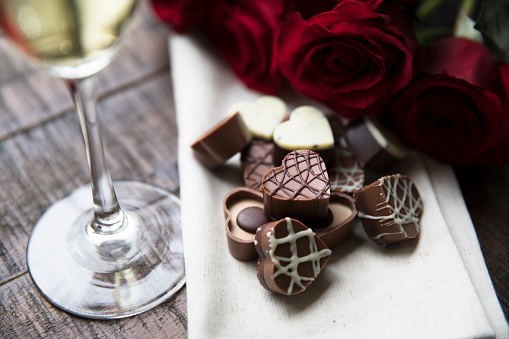 Romantic heart shaped chocolates with red roses and champagne.