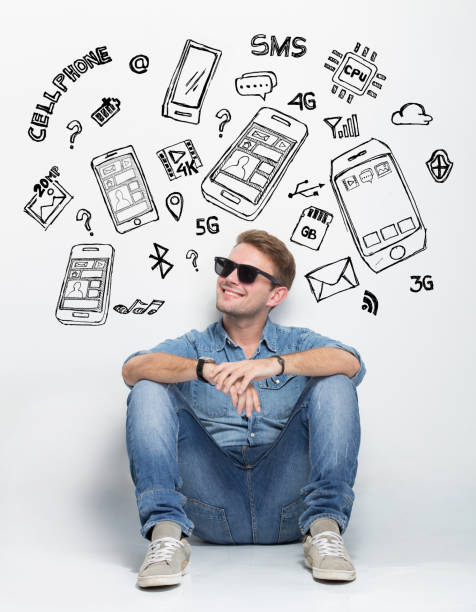 Young caucasian man sitting on the floor thingking A portrait of Young caucasian man wear sunglasses while sitting on the floor thingking about having a new smartphone good looking man looking up stock illustrations