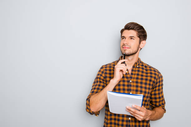 istock Portrait of minded man with notebook isolated on gray background 638845074